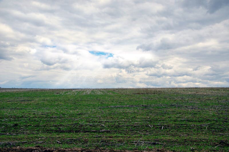 Een bewolkte hemel met het doordringen van stralen van de zon over een groen gebied royalty-vrije stock foto's Een bewolkte hemel met het doordringen van stralen van de zon over een groen gebied royalty-vrije stock foto's