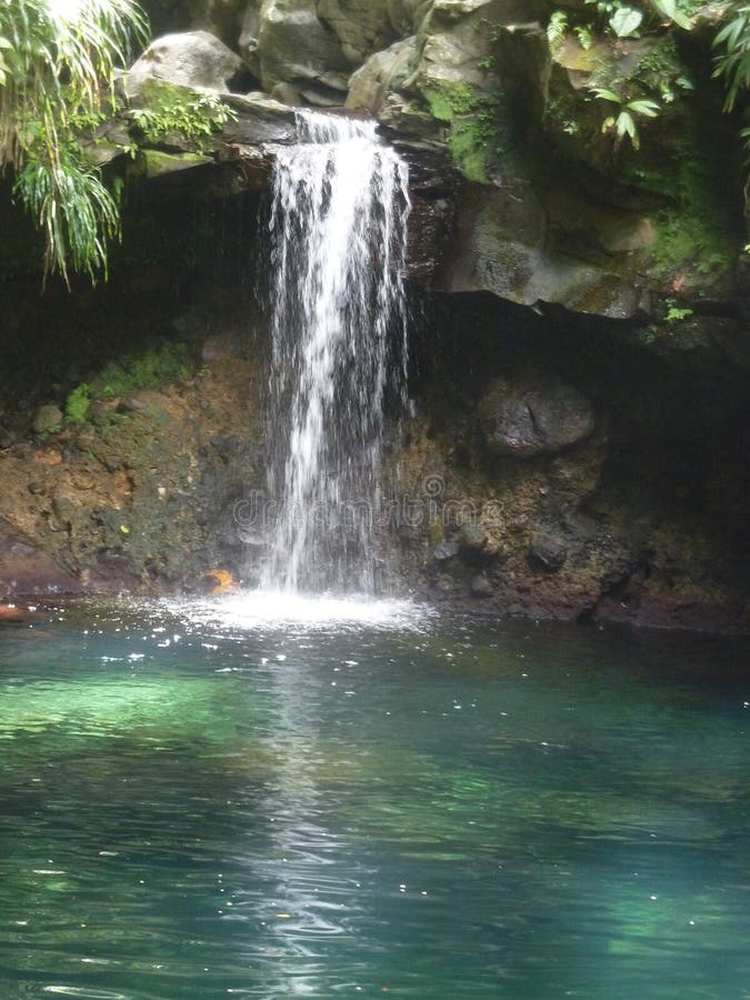 Een blauwbekken van turkooizen met een kleine waterval royalty-vrije stock afbeeldingen Een blauwbekken van turkooizen met een kleine waterval royalty-vrije stock afbeeldingen