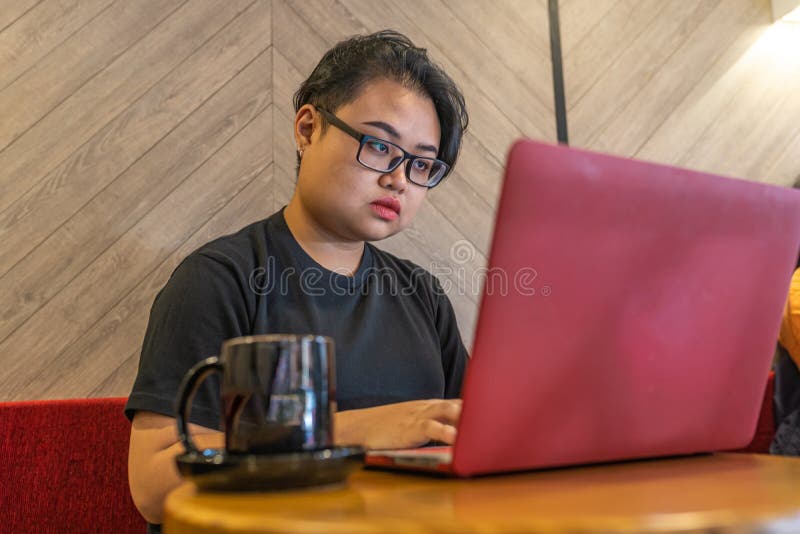 Een bril dragen van Aziatische lesbiennes met laptop en koffie royalty-vrije stock foto Een bril dragen van Aziatische lesbiennes met laptop en koffie royalty-vrije stock foto
