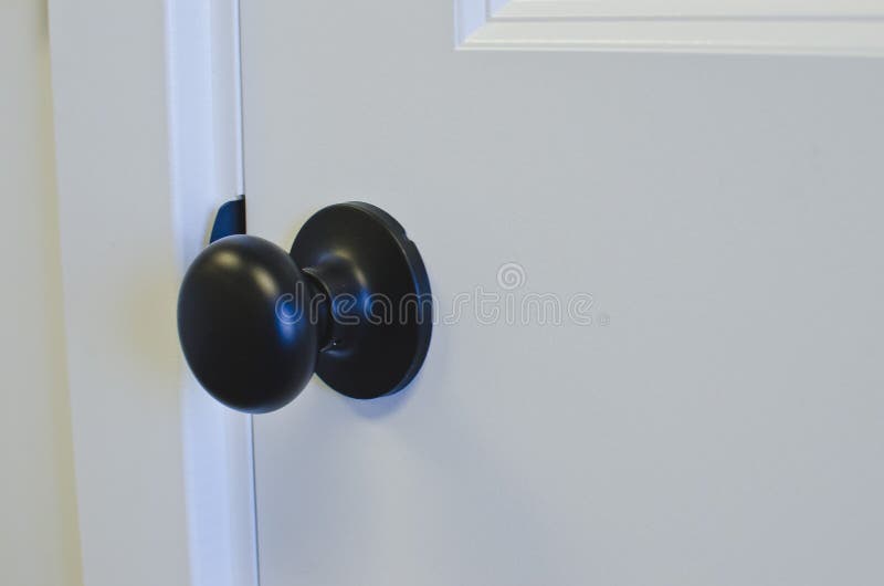Een brons om knop op de nieuwe deur stock fotografie Een brons om knop op de nieuwe deur stock fotografie