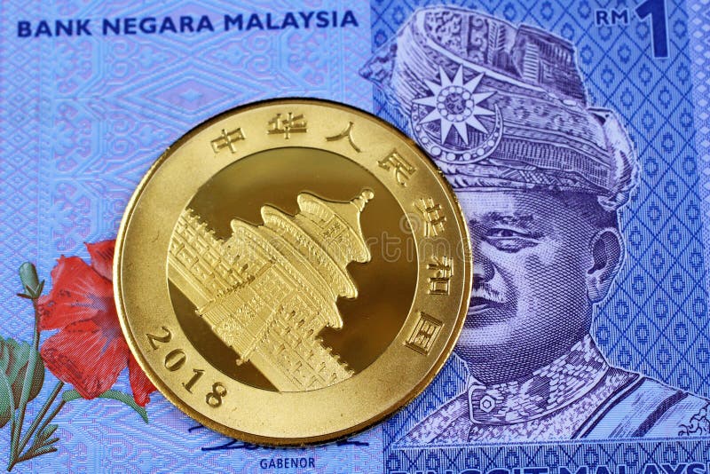 Een Chinees gouden muntstuk met Maleise ringgit bankbiljet stock foto's Een Chinees gouden muntstuk met Maleise ringgit bankbiljet stock foto's