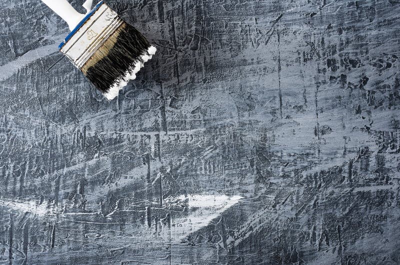 Een deel van de borstel in zwart-witte verf op de achtergrond van een concrete geschilderde grijze achtergrond bij de verlaten bo stock foto Een deel van de borstel in zwart-witte verf op de achtergrond van een concrete geschilderde grijze achtergrond bij de verlaten bo stock foto