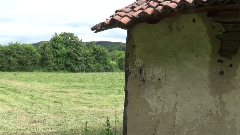 Een deel van de muur en het dak van een oud en verlaten huis