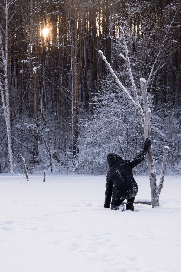 Een eenzame mens loopt in de sneeuw Dramatisch silhouet van een mens die in een sneeuwopheldering in het bos koud lopen stock fotografie Een eenzame mens loopt in de sneeuw Dramatisch silhouet van een mens die in een sneeuwopheldering in het bos koud lopen stock fotografie