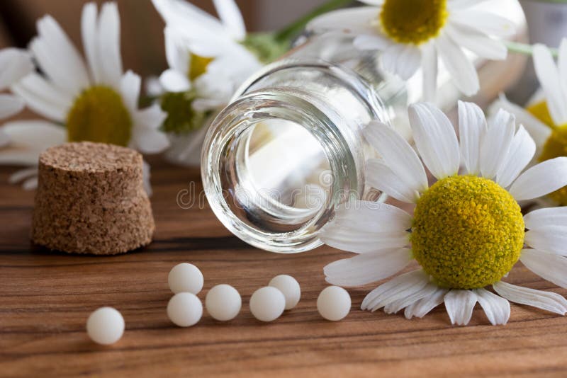 Een fles van homeopathische druppeltjes met kamille bloeit royalty-vrije stock afbeeldingen Een fles van homeopathische druppeltjes met kamille bloeit royalty-vrije stock afbeeldingen