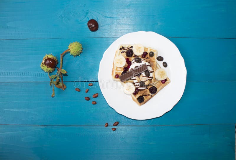 Een foto van twee Weense die wafeltjes, met chocolade met bessen en roomijs op een houten lijst aangaande de raad wordt gegoten k royalty-vrije stock afbeelding Een foto van twee Weense die wafeltjes, met chocolade met bessen en roomijs op een houten lijst aangaande de raad wordt gegoten k royalty-vrije stock afbeelding