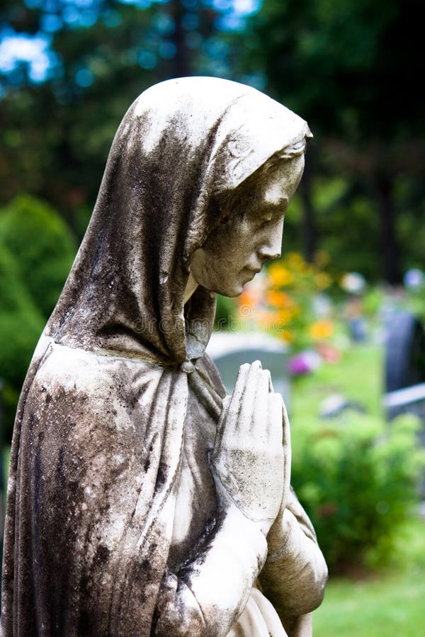 The Virgin Mary Statue praying in a garden. The Virgin Mary Statue praying in a garden