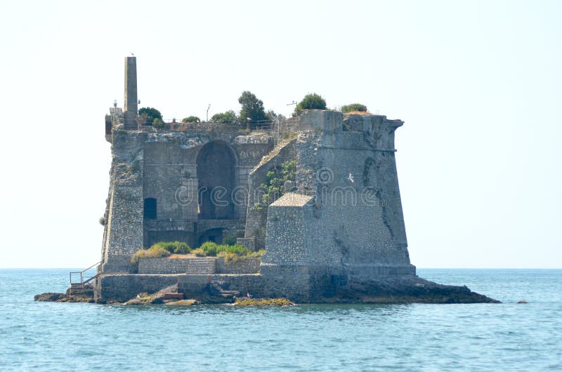 Een geruïneerde toren op een rotsachtig eiland stock afbeeldingen