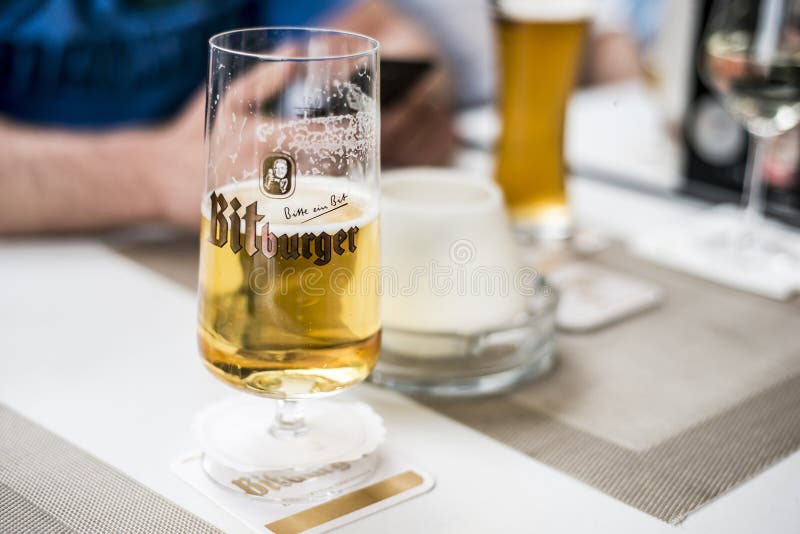 Een Glas Duits Bier Op Een Lijst Met Het Embleem Van Het Bitburgerbedrijf Redactionele Foto Image of licht, vers: 106622156