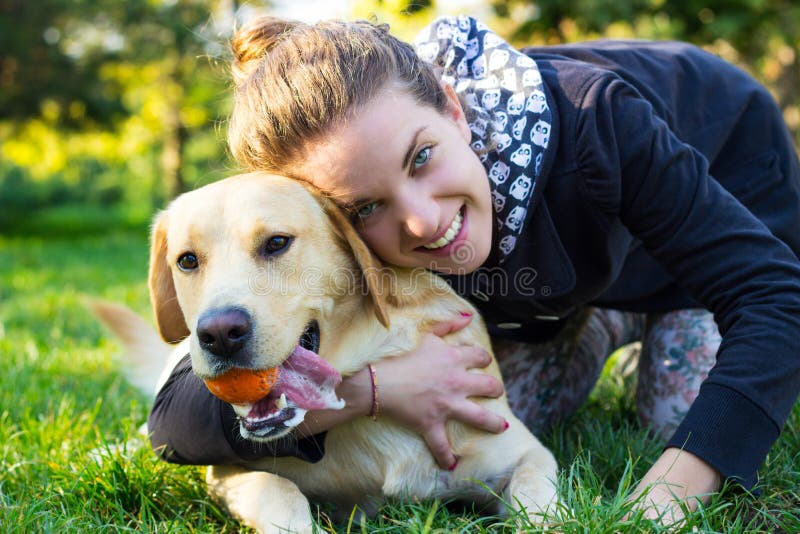 Een glimlachend meisje speelt met haar hond stock fotografie Een glimlachend meisje speelt met haar hond stock fotografie