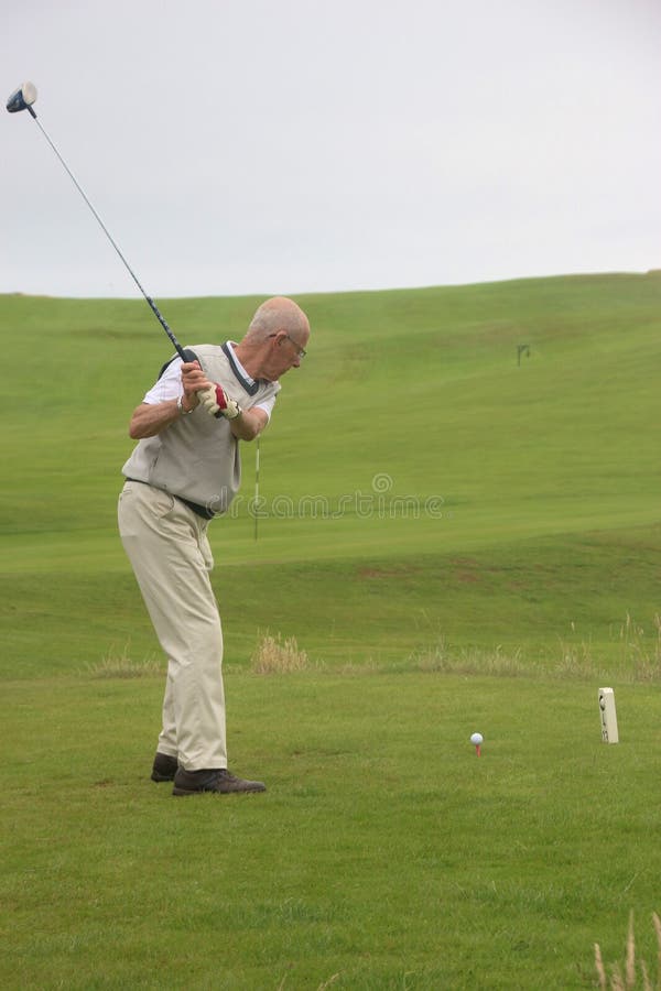 Een golfer speelt golf op de golfbaan van St. Bees, Engeland stock afbeelding Een golfer speelt golf op de golfbaan van St. Bees, Engeland stock afbeelding