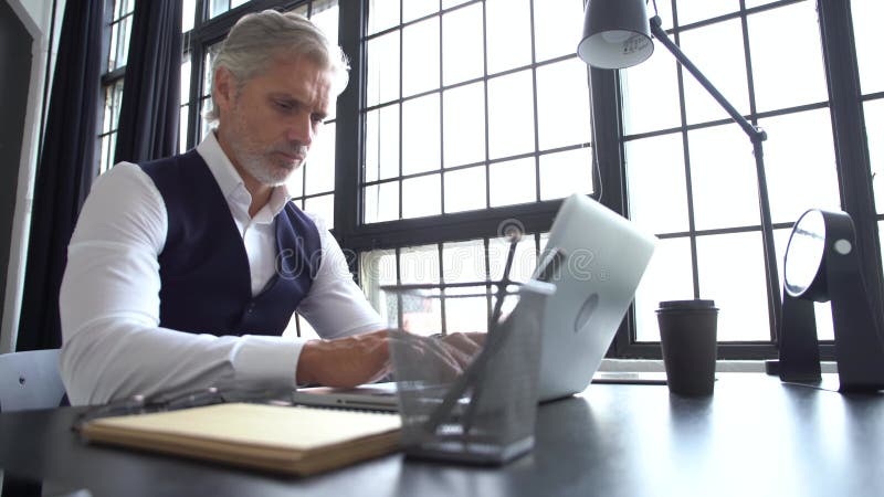 Een griekse man die werkt op een laptop. volwassen man in een elegant pak