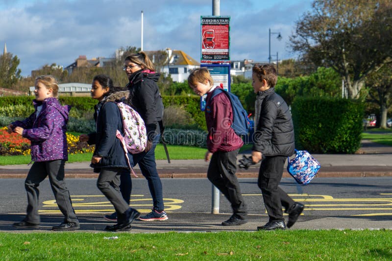 Een groep Britse schoolkinderen die langs een bushalte lopen stock foto's Een groep Britse schoolkinderen die langs een bushalte lopen stock foto's