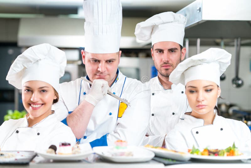 Een groep chef-koks die met heerlijke maaltijd in hoog luxerestaurant stellen royalty-vrije stock foto's Een groep chef-koks die met heerlijke maaltijd in hoog luxerestaurant stellen royalty-vrije stock foto's