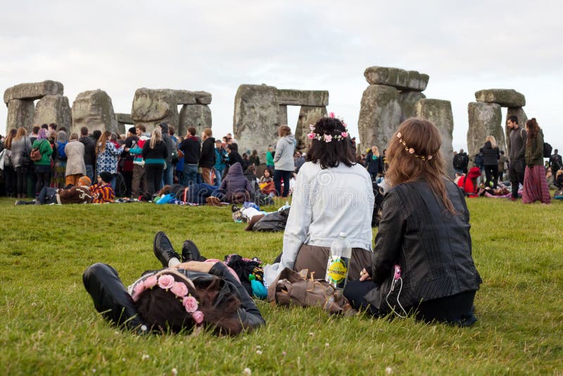 Een groep meisjes met bloemen in hun feestneuzen van het haarhorloge bij Stonehenge-de zomerzonnestilstand stock afbeeldingen Een groep meisjes met bloemen in hun feestneuzen van het haarhorloge bij Stonehenge-de zomerzonnestilstand stock afbeeldingen