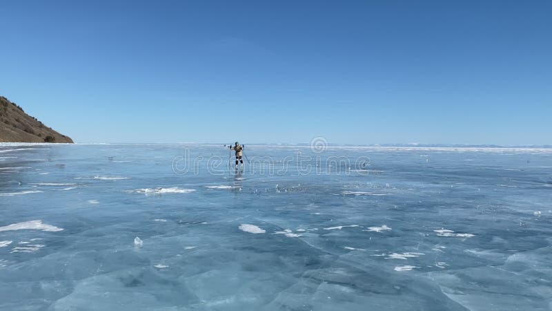 Een groep toeristen reist op schaatsen op het ijs van het diepgevroren meer baikal.