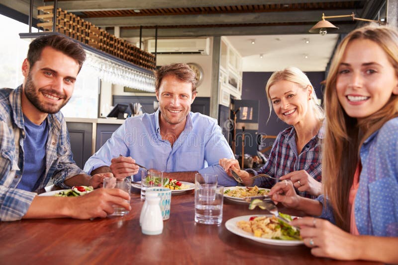 Een groep vrienden die bij een restaurant eten stock foto's Een groep vrienden die bij een restaurant eten stock foto's
