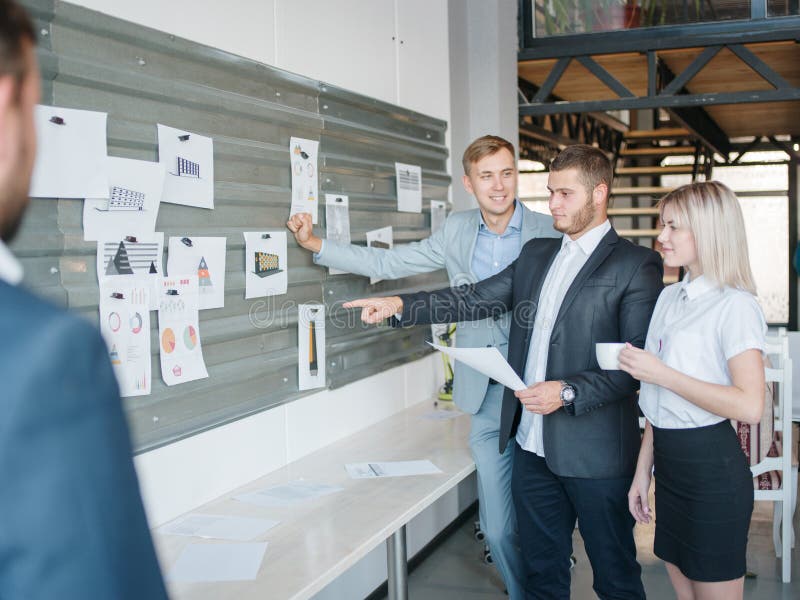 Een groep zakenlieden bekijkt de raad voor diverse grafiek en projecten stock afbeeldingen Een groep zakenlieden bekijkt de raad voor diverse grafiek en projecten stock afbeeldingen