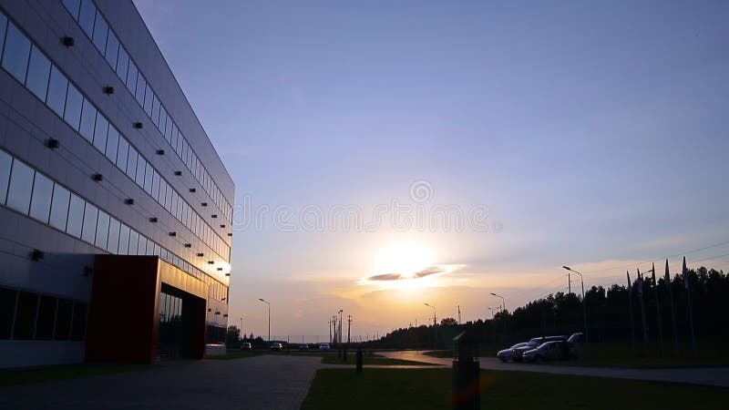 Een groot industrieel gebouw bij zonsondergang