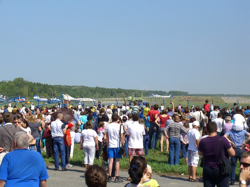 Een grote menigte van mensen bij het festival die op de lucht letten toont in Novosibirsk bij de luchthaven royalty-vrije stock fotografie Een grote menigte van mensen bij het festival die op de lucht letten toont in Novosibirsk bij de luchthaven royalty-vrije stock fotografie
