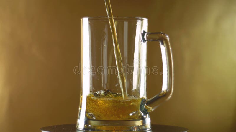 In een grote mok die een gegoten donker bier op een gouden achtergrond, Oktoberfest wordt royalty-vrije stock foto's In een grote mok die een gegoten donker bier op een gouden achtergrond, Oktoberfest wordt royalty-vrije stock foto's