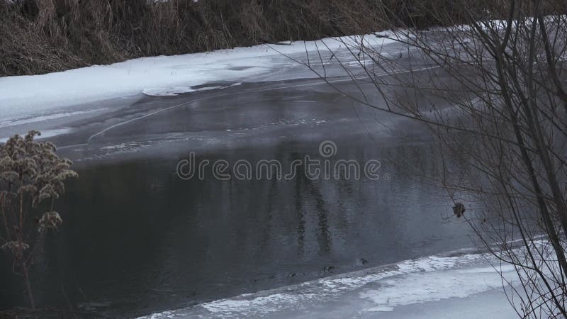 Een halfbevroren rivier bij de schemering