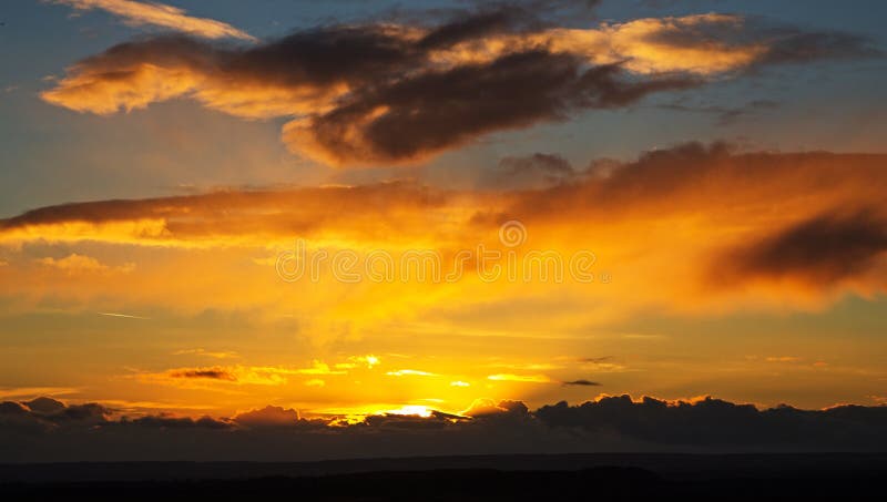 Een Heldere Zonsondergang tegen een Bewolkte Hemel stock afbeeldingen Een Heldere Zonsondergang tegen een Bewolkte Hemel stock afbeeldingen