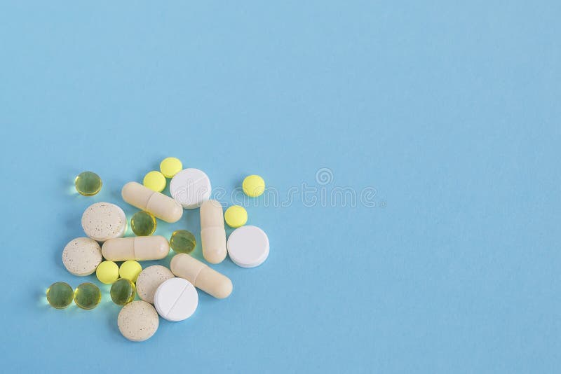 Een hoop van verschillende pillen en capsules op een blauwe achtergrond Om ziek te worden, neem pillen of onderga behandeling Con royalty-vrije stock fotografie Een hoop van verschillende pillen en capsules op een blauwe achtergrond Om ziek te worden, neem pillen of onderga behandeling Con royalty-vrije stock fotografie