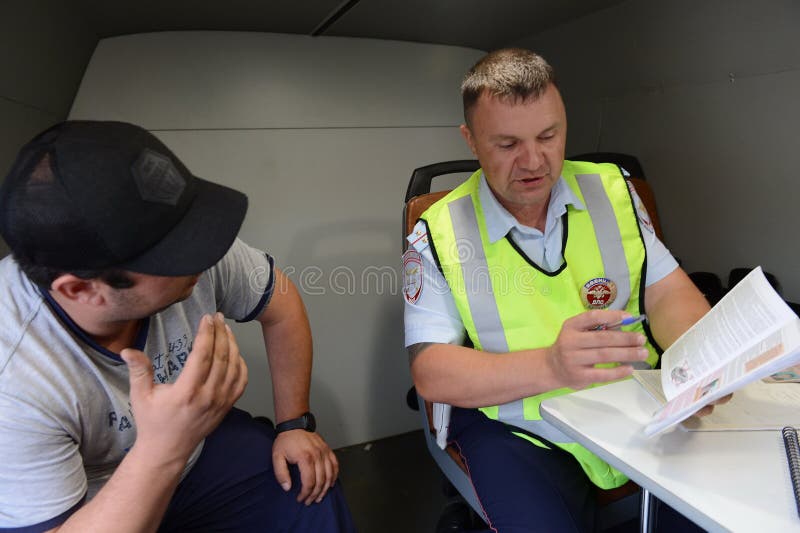 Een inspecteur van de de patrouilledienst van de wegpolitie brengt verslag over de schending van verkeersregels uit royalty-vrije stock fotografie Een inspecteur van de de patrouilledienst van de wegpolitie brengt verslag over de schending van verkeersregels uit royalty-vrije stock fotografie