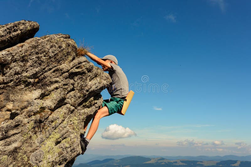 Een 11-jarige jongen bestudeert de bergbeklimming in de Karpaten, een jongen klimt alleen tot de top van een rotsachtige steen zo
