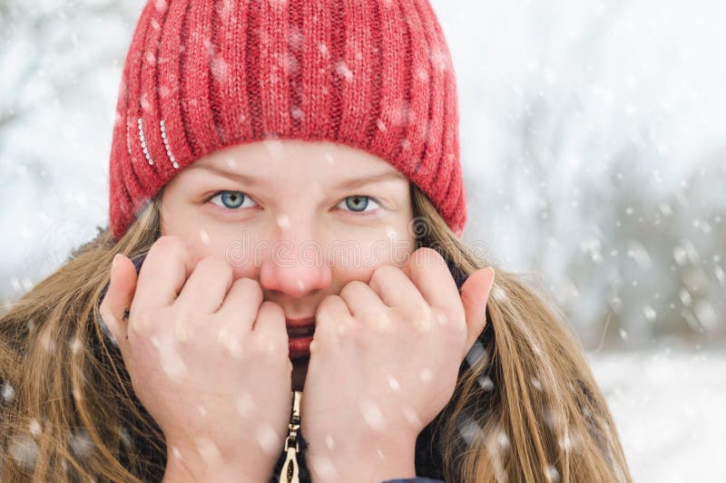 Een jong blondemeisje houdt een kraag in haar handen om tot het verwarmingstoestel te maken, en glimlacht onder zachte pluizige s stock foto Een jong blondemeisje houdt een kraag in haar handen om tot het verwarmingstoestel te maken, en glimlacht onder zachte pluizige s stock foto