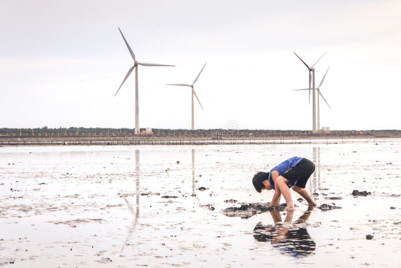 Een Jong Kind die met Modder in Gaomei-Moerasland spelen Een Jong Kind die met Modder in Gaomei-Moerasland spelen