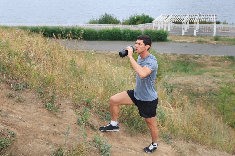 Een jonge mens die op de sleep lopen de levensstijlconcept van de reissport Jonge atleet die zoet water drinken royalty-vrije stock afbeeldingen Een jonge mens die op de sleep lopen de levensstijlconcept van de reissport Jonge atleet die zoet water drinken royalty-vrije stock afbeeldingen