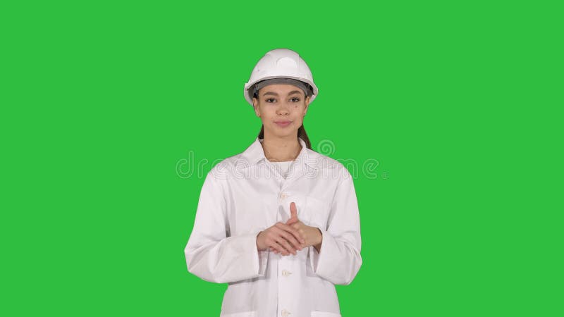 Een jonge mooie ingenieur van de vrouwenwetenschapper in wit die lezing op het Groen Scherm geven, Chromasleutel