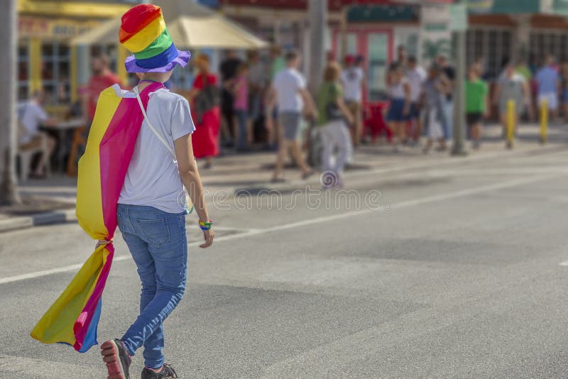 Een jonge vrouw die een van de trots hoogste hete en de kaapgang weg dragen regenboogvlag stock afbeelding Een jonge vrouw die een van de trots hoogste hete en de kaapgang weg dragen regenboogvlag stock afbeelding