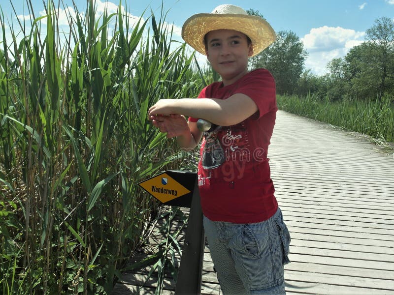 Een jongen leunt tegen een toeristenbord royalty-vrije stock foto Een jongen leunt tegen een toeristenbord royalty-vrije stock foto