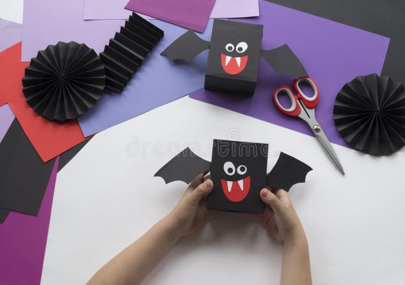 Een kind die Halloween-decoratie van gekleurd document maken stock foto's Een kind die Halloween-decoratie van gekleurd document maken stock foto's