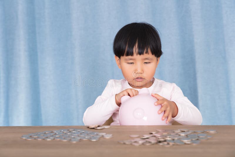 Een klein kind dat speelt met een spaarpot in handen stock foto