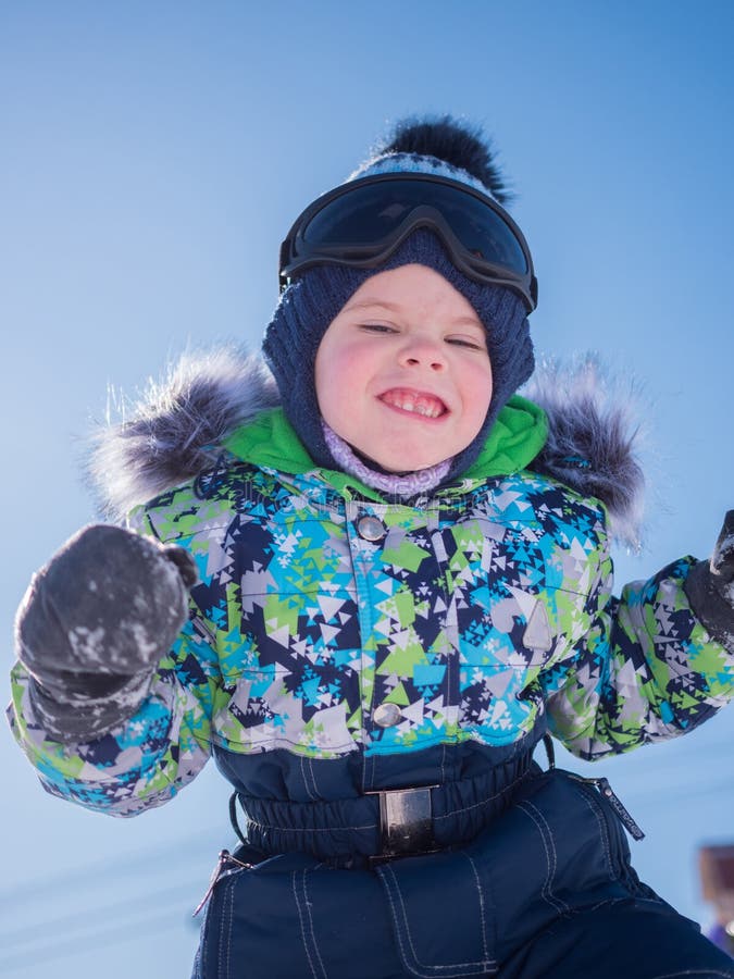 Een klein kind die in het de winterpark spelen Speel en glimlachende baby op blauwe achtergrond Actieve rust en spelen royalty-vrije stock foto's Een klein kind die in het de winterpark spelen Speel en glimlachende baby op blauwe achtergrond Actieve rust en spelen royalty-vrije stock foto's