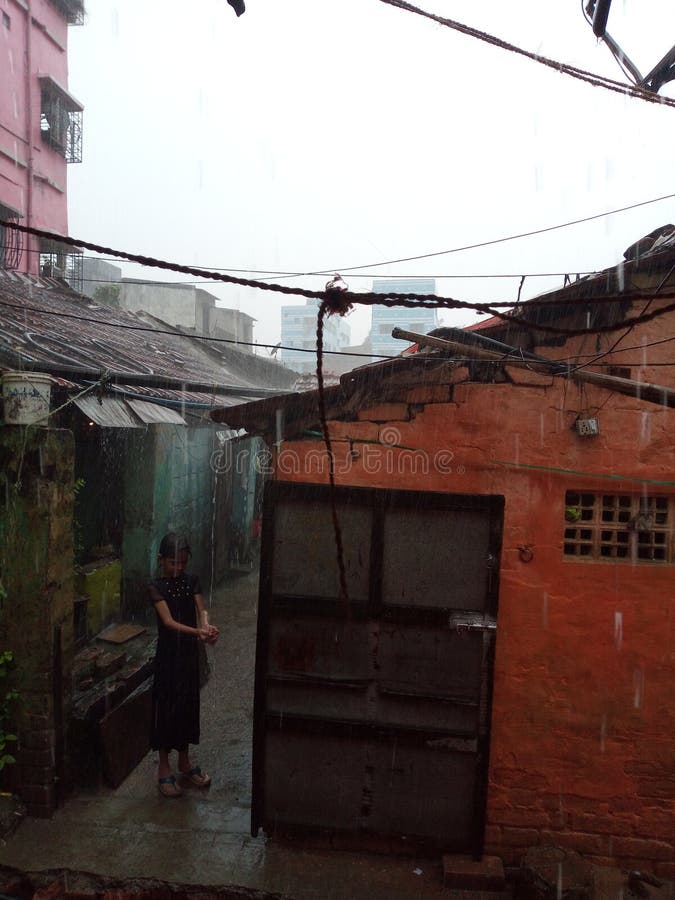 Een klein meisje die pret met het regenen doen stock foto's Een klein meisje die pret met het regenen doen stock foto's