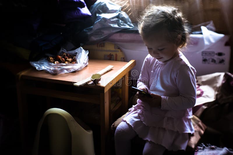 Een klein meisje leert over Internet door een mobiele telefoon royalty-vrije stock fotografie Een klein meisje leert over Internet door een mobiele telefoon royalty-vrije stock fotografie