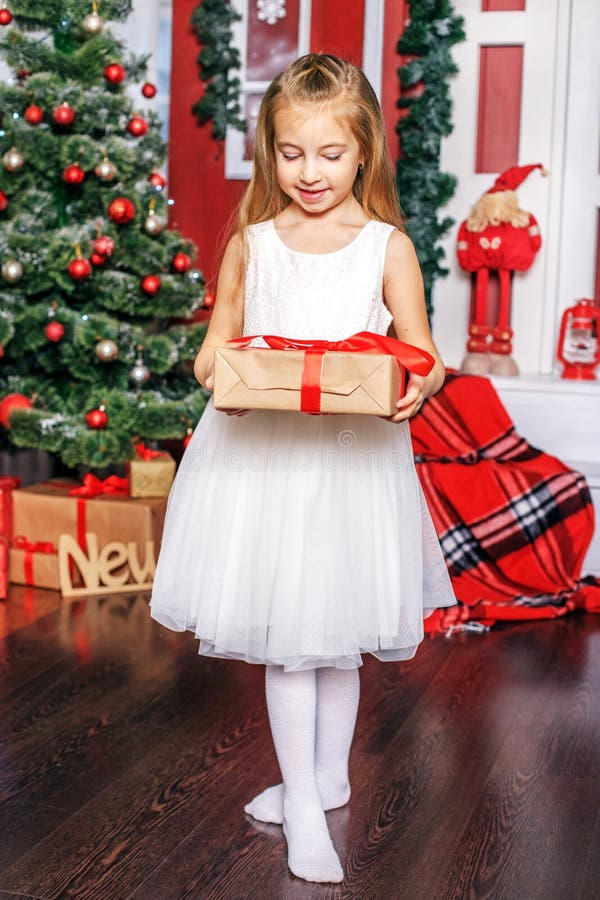 Een klein meisje opent een giftdoos Conceptennieuwjaar, Vrolijke Christma stock foto's Een klein meisje opent een giftdoos Conceptennieuwjaar, Vrolijke Christma stock foto's