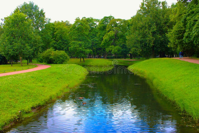 Een klein rivierkanaal in een de zomerpark stock afbeeldingen Een klein rivierkanaal in een de zomerpark stock afbeeldingen