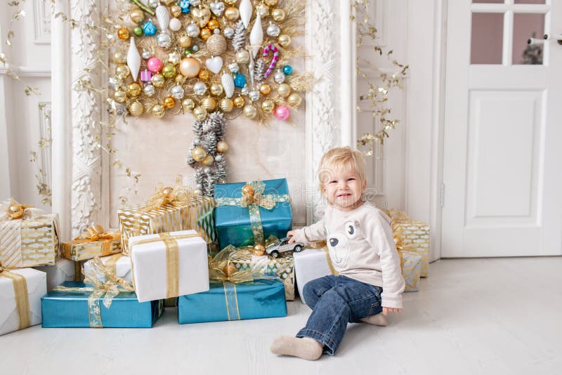Een kleine jongen bevindt zich dichtbij heel wat giften Gelukkig Nieuwjaar Verfraaide Kerstboom Kerstmisochtend in het heldere le stock afbeeldingen Een kleine jongen bevindt zich dichtbij heel wat giften Gelukkig Nieuwjaar Verfraaide Kerstboom Kerstmisochtend in het heldere le stock afbeeldingen
