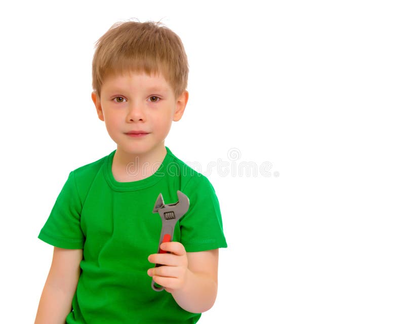 Een kleine jongen houdt een moersleutel in zijn hand royalty-vrije stock foto's Een kleine jongen houdt een moersleutel in zijn hand royalty-vrije stock foto's