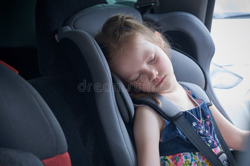 Een kleine meisjesslaap in een comfortabele autozetel voor kinderen royalty-vrije stock afbeelding Een kleine meisjesslaap in een comfortabele autozetel voor kinderen royalty-vrije stock afbeelding
