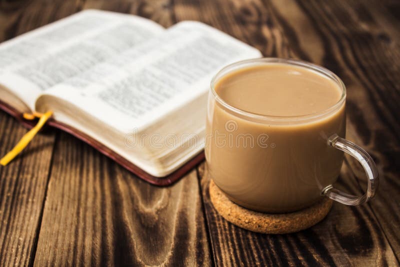 Een kop van koffie en bijbel op houten achtergrond stock fotografie Een kop van koffie en bijbel op houten achtergrond stock fotografie