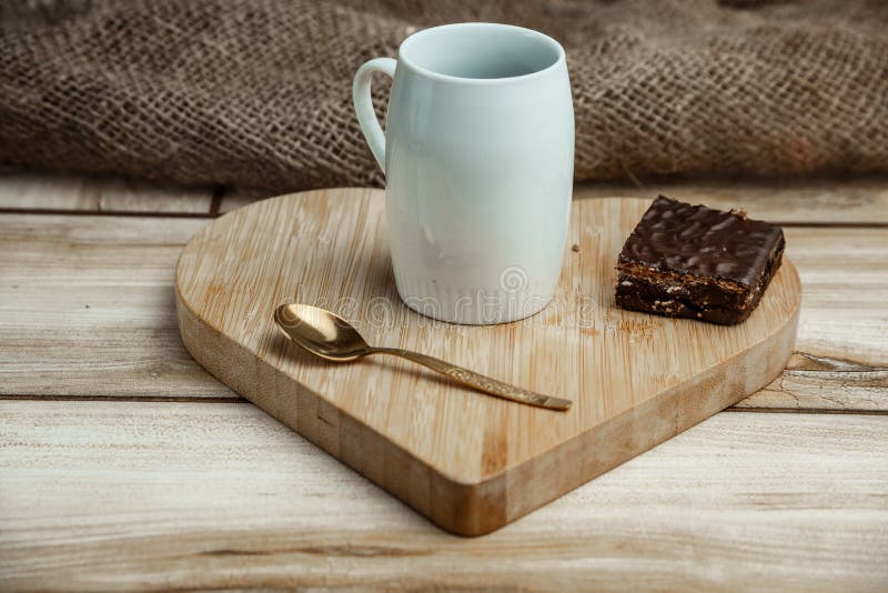 Een kop van koffie met een cake van de chocoladewafel op een houten hart-vormig dienblad royalty-vrije stock foto's Een kop van koffie met een cake van de chocoladewafel op een houten hart-vormig dienblad royalty-vrije stock foto's