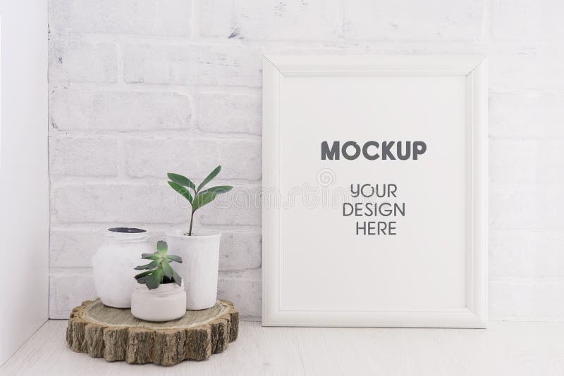 Empty picture mockup with wooden frame on white brick wall background with succulents plants on a wooden cut. Light interior. Empty picture mockup with wooden frame on white brick wall background with succulents plants on a wooden cut. Light interior