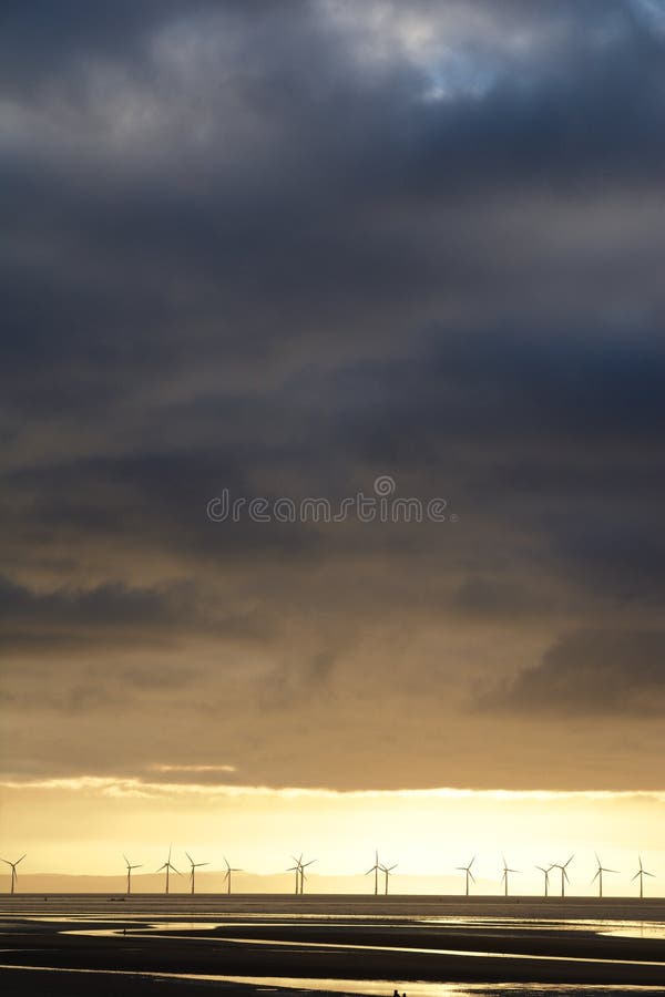 Een lijn windturbines ligt aan de horizon op volle zee royalty-vrije stock foto's Een lijn windturbines ligt aan de horizon op volle zee royalty-vrije stock foto's